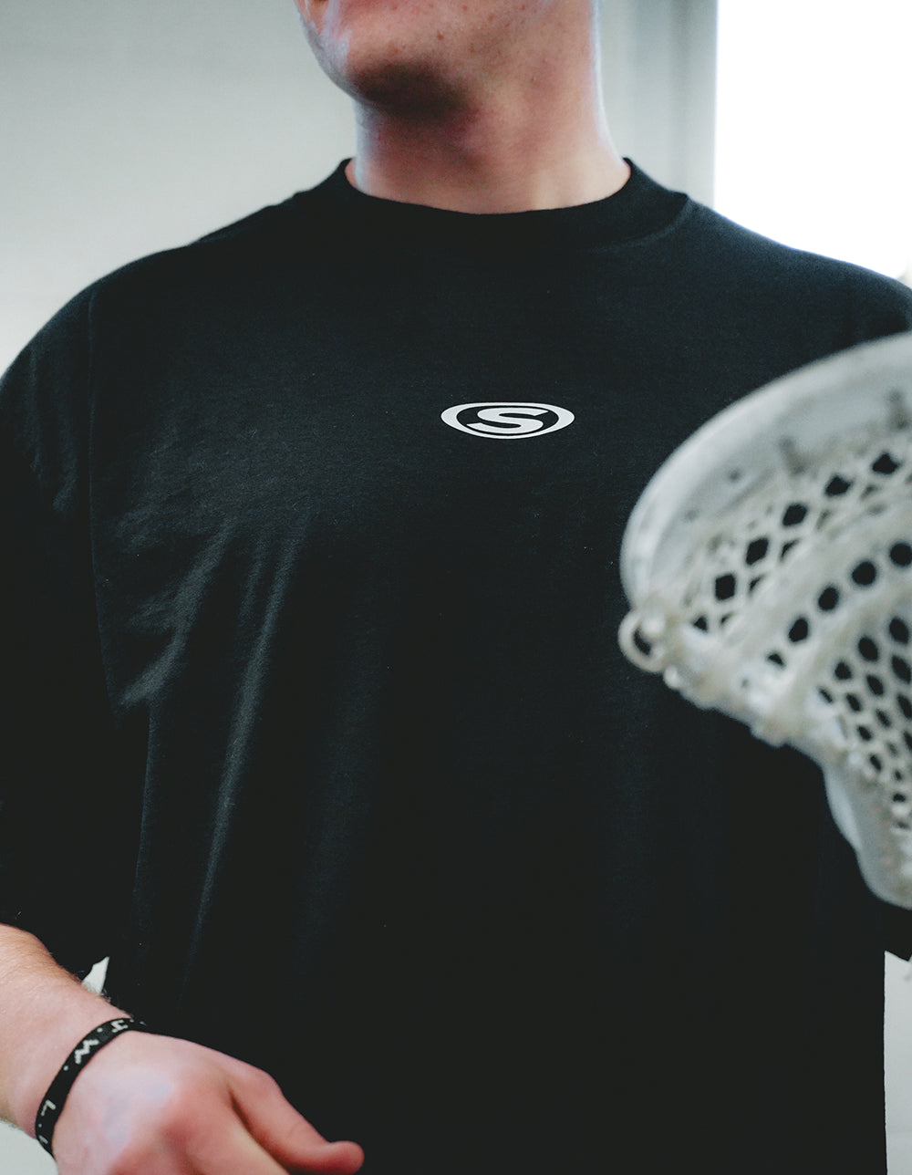 Fastest Game black lacrosse tee front logo lifestyle